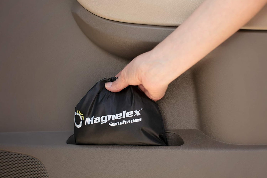 Hand holding a Magnelex sunshades bag inside a vehicle.