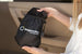“A hand placing a compact Magnelex sunshade storage pouch into a car door pocket, highlighting easy storage and portability.”