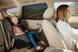 Mesh car side window sunshade providing UV protection for a child in a car seat, reducing glare and heat inside the vehicle.