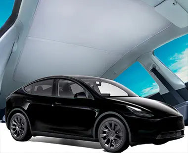 A black Tesla Model Y with a roof sunshade installed, blocking sunlight through the panoramic glass roof.
